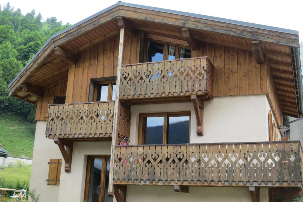 uma casa de madeira com uma varanda e janelas em Chalet Philippe em Peisey-Nancroix