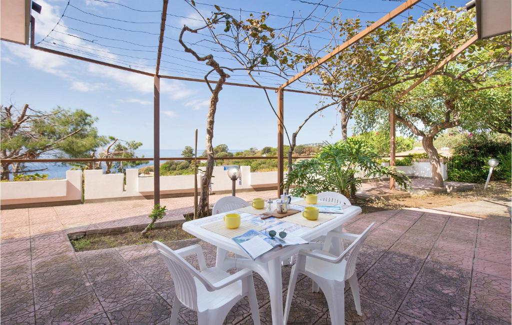 - une table et des chaises blanches sur la terrasse dans l'établissement Villa Sarah, à Ioppolo