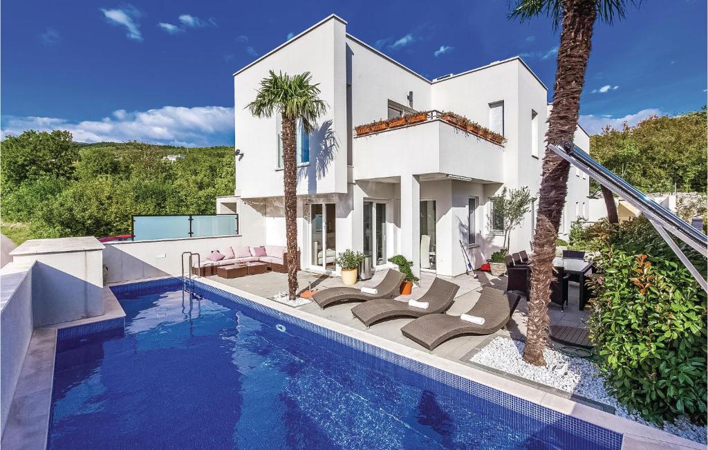 eine Villa mit einem Pool vor einem Haus in der Unterkunft Amazing Home In Crikvenica With 4 Bedrooms, Wifi And Outdoor Swimming Pool in Crikvenica
