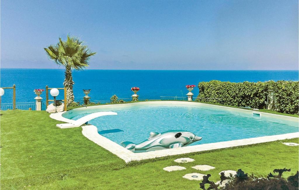 a swimming pool with a whale in the grass at Villa Oceania in Mandra Capreria