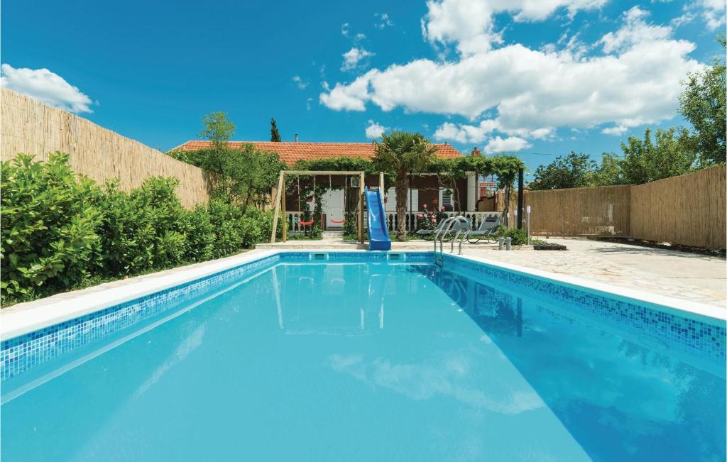 a swimming pool with blue water in a backyard at Awesome Home In Sibenik With Wifi in Šibenik
