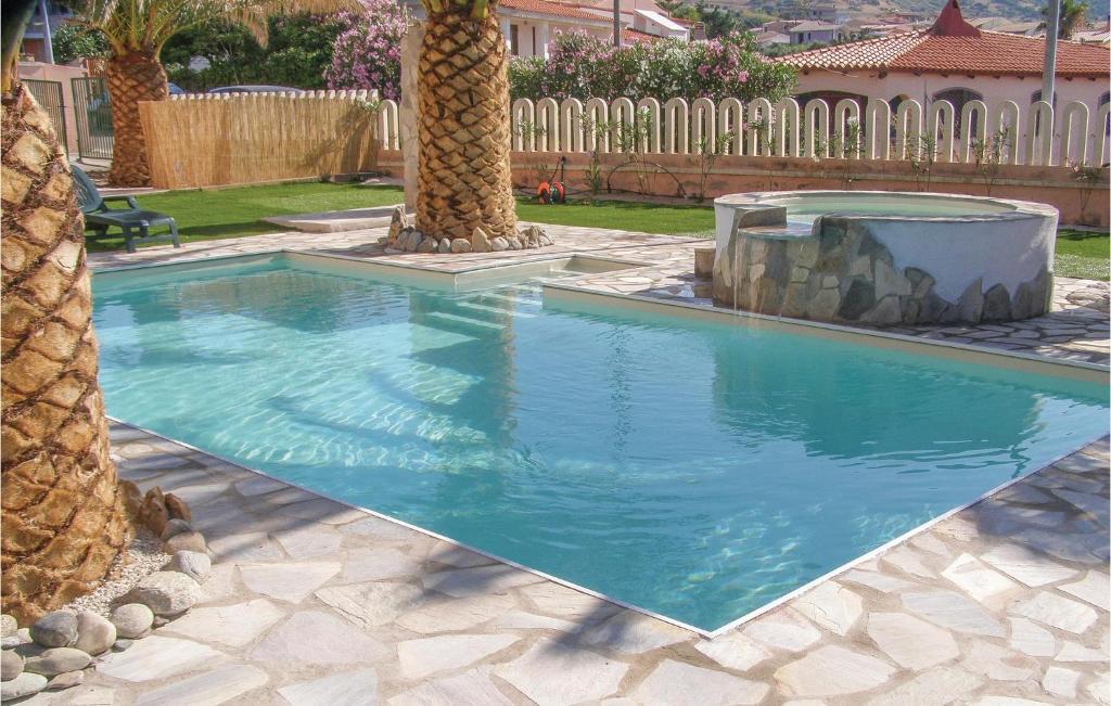 uma piscina com uma palmeira num quintal em Casa Margherita 2 em Codaruina
