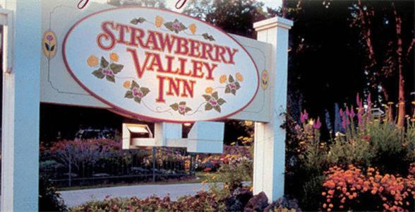 a sign for a strawberryarity valley inn in a garden at Strawberry Valley Inn in Mount Shasta