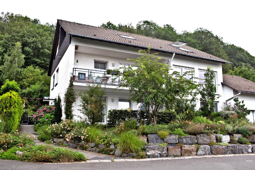 a white house with a garden in front of it at Ferienwohnung Klebeck in Lüdenscheid