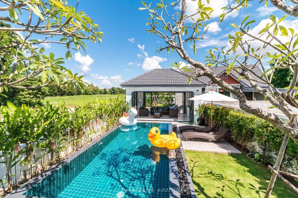 a swimming pool with a toy rubber duck in a backyard at BAAN DALAH POOL VILLA in Buriram