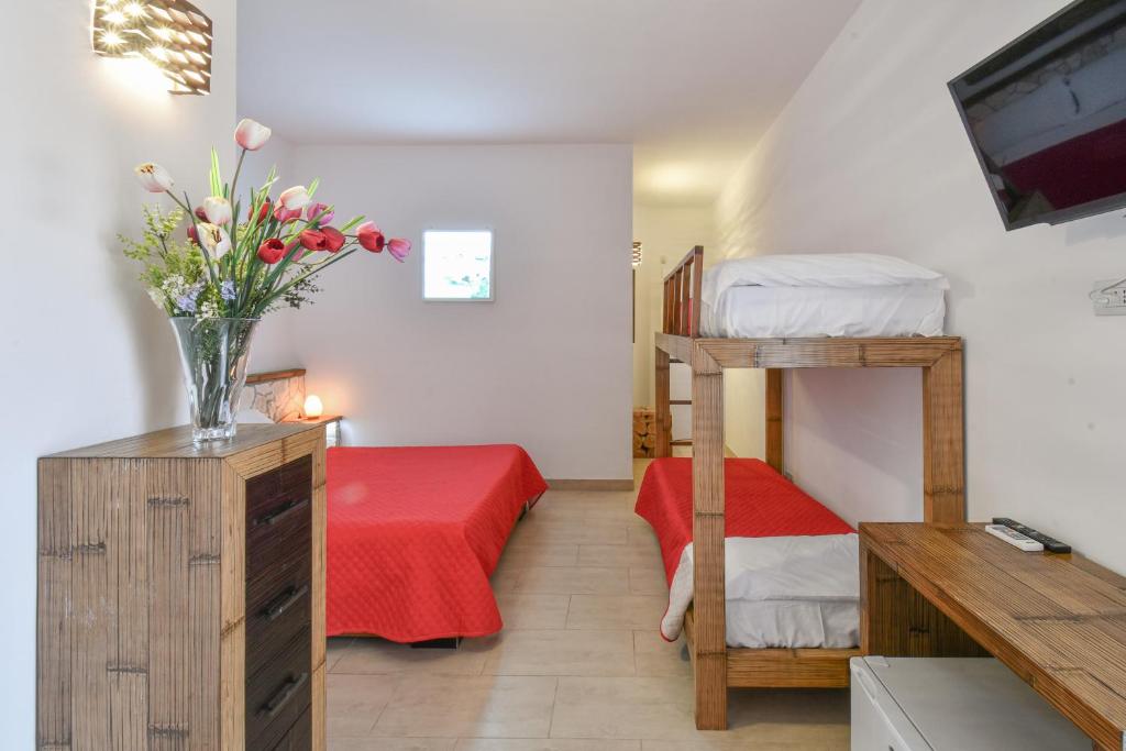 a bedroom with a bunk bed and a vase of flowers at Calasole Country House in Torre Lapillo