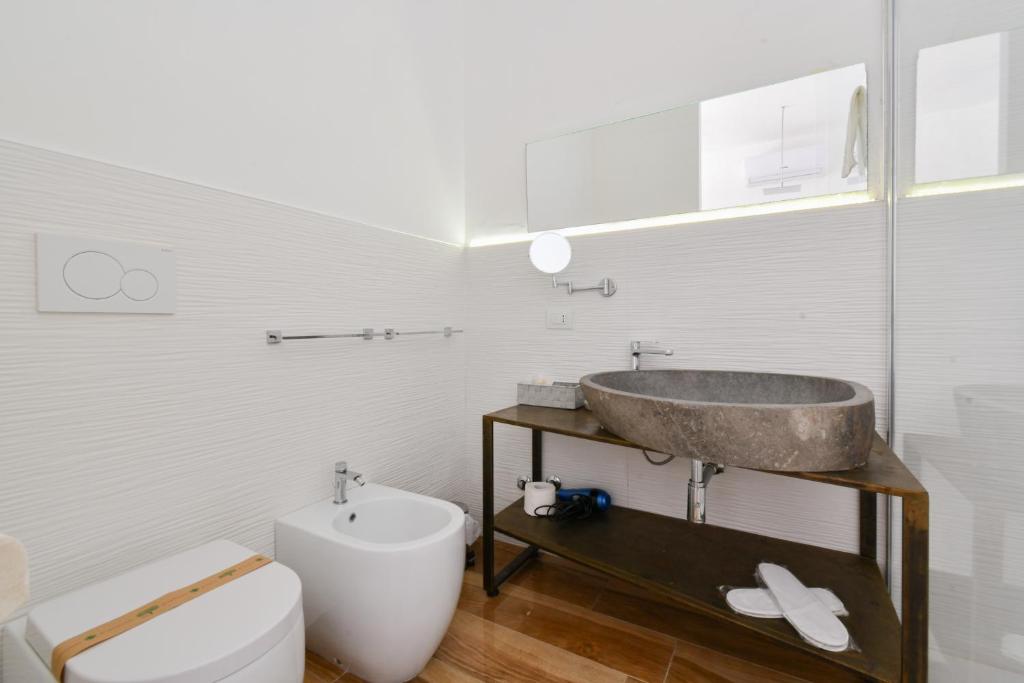 a bathroom with a sink and a toilet at Calasole Country House in Torre Lapillo