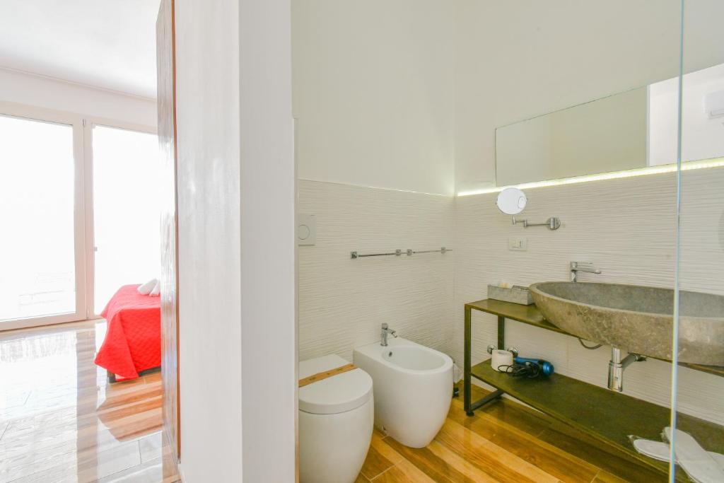 a bathroom with a tub and a sink and a toilet at Calasole Country House in Torre Lapillo