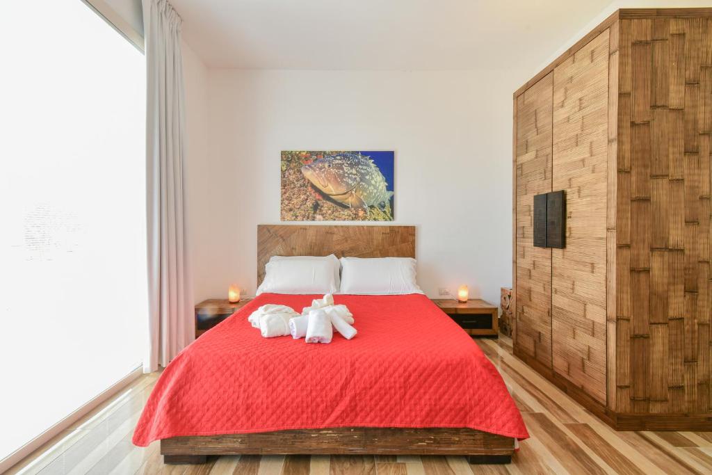 a bedroom with two white cats laying on a red bed at Calasole Country House in Torre Lapillo