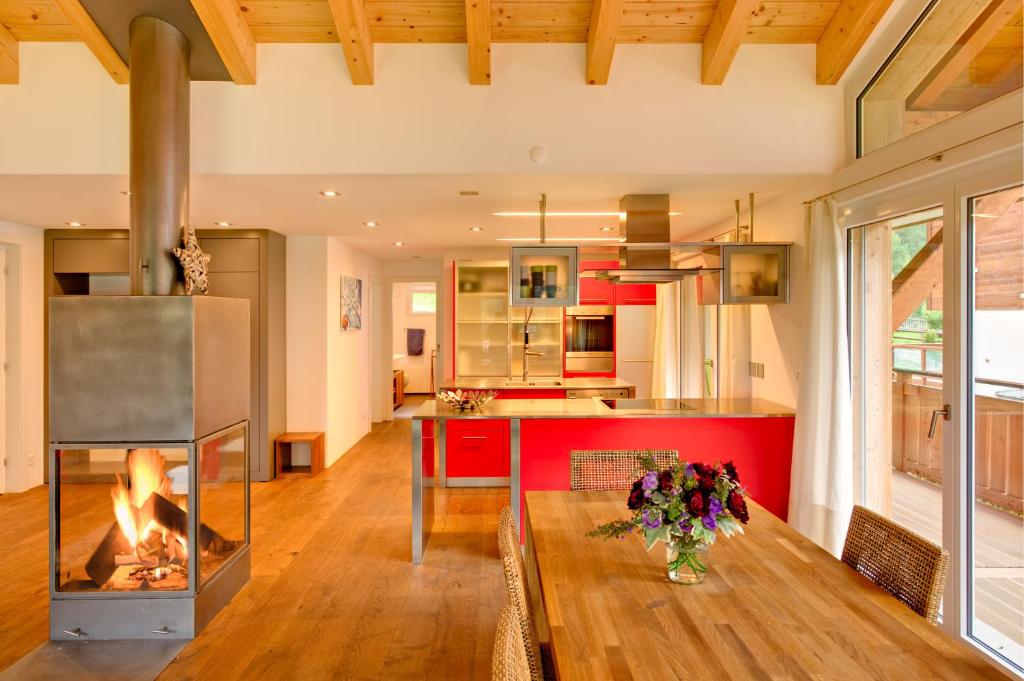 a kitchen with a fireplace and a table in a room at Apartment Windward in Zermatt
