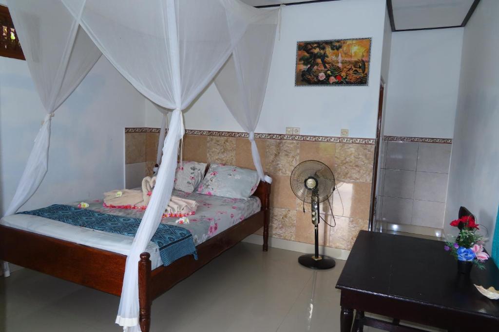 a bedroom with a bed with a canopy at Pondok Lembah Dukuh Homestay in Tirtagangga
