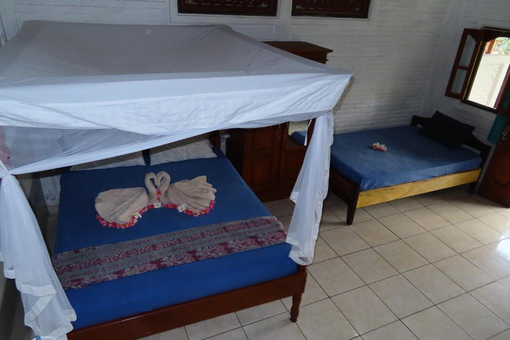a bedroom with a bed with a canopy at Pondok Lembah Dukuh Homestay in Tirtagangga