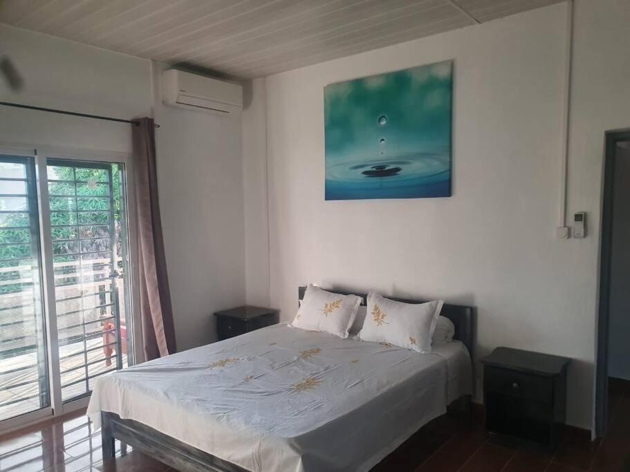 um quarto com uma cama com uma fotografia na parede em T3 haut standing avec accès & parking privé em Bandraboua