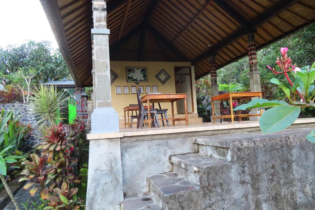 a porch of a house with a table and chairs at Pondok Lembah Dukuh Homestay in Tirtagangga