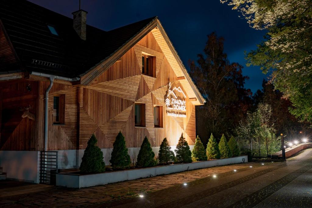 a house with lights on the side of it at night at Zimowy Domek Boutique Rooms - Adults Only Vege in Świeradów-Zdrój