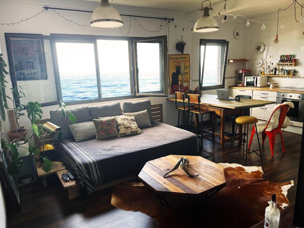 a living room with a couch and a table at Villa Atlántida. Precioso apartamento con ventanas al mar in Santa Maria de Guia de Gran Canaria