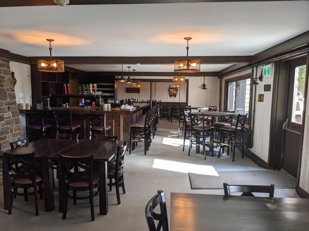 a restaurant with tables and chairs and a bar at Inn at the Falls in Bracebridge