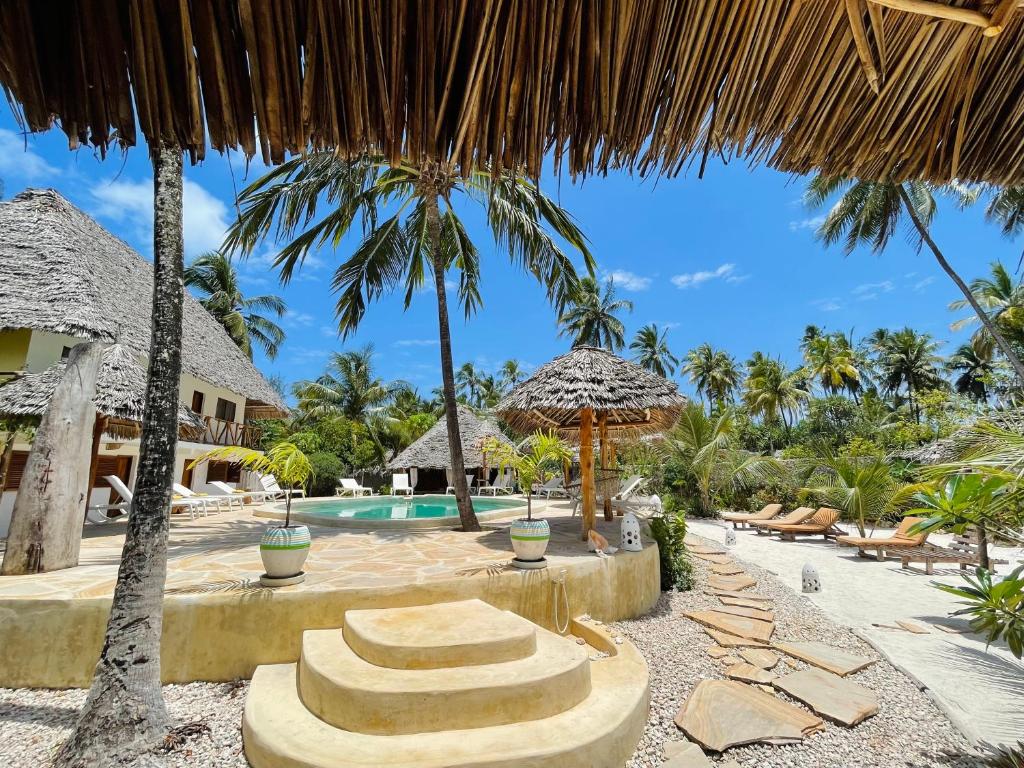 um resort com piscina e palmeiras em Oleza Boutique Hotel Zanzibar em Michamvi