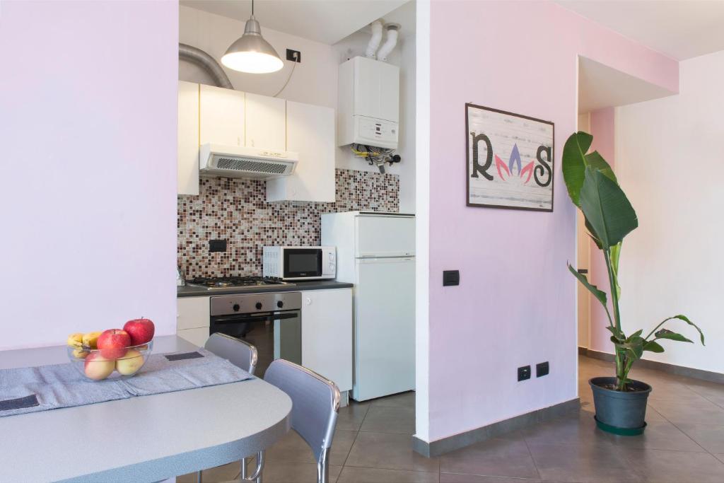 a kitchen with a table and a white refrigerator at Residenza Sant'Anna in Cuggiono