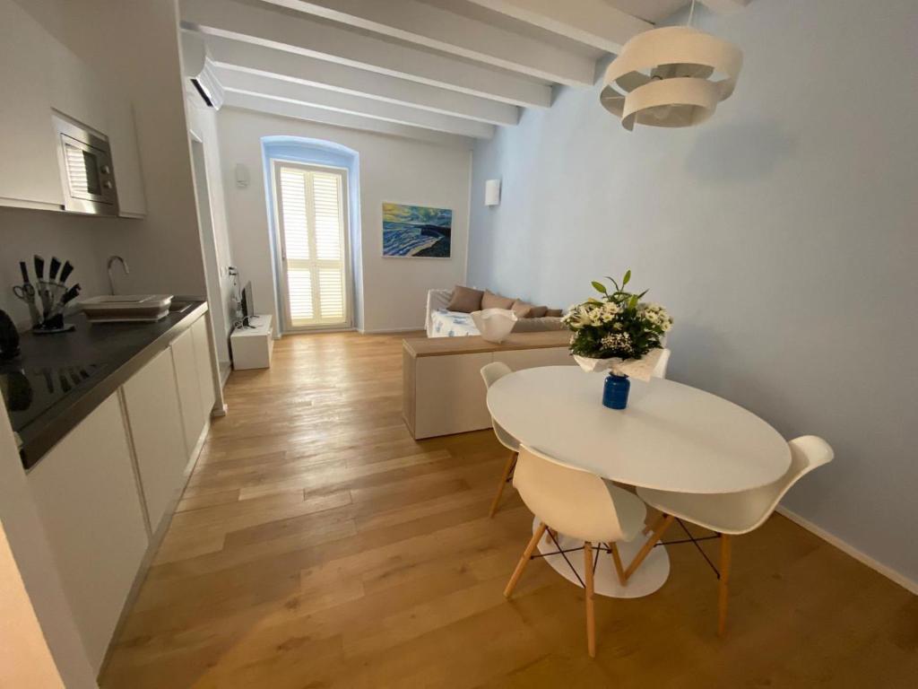 kuchnia i salon ze stołem i krzesłami w obiekcie Le Vele Carloforte w mieście Carloforte