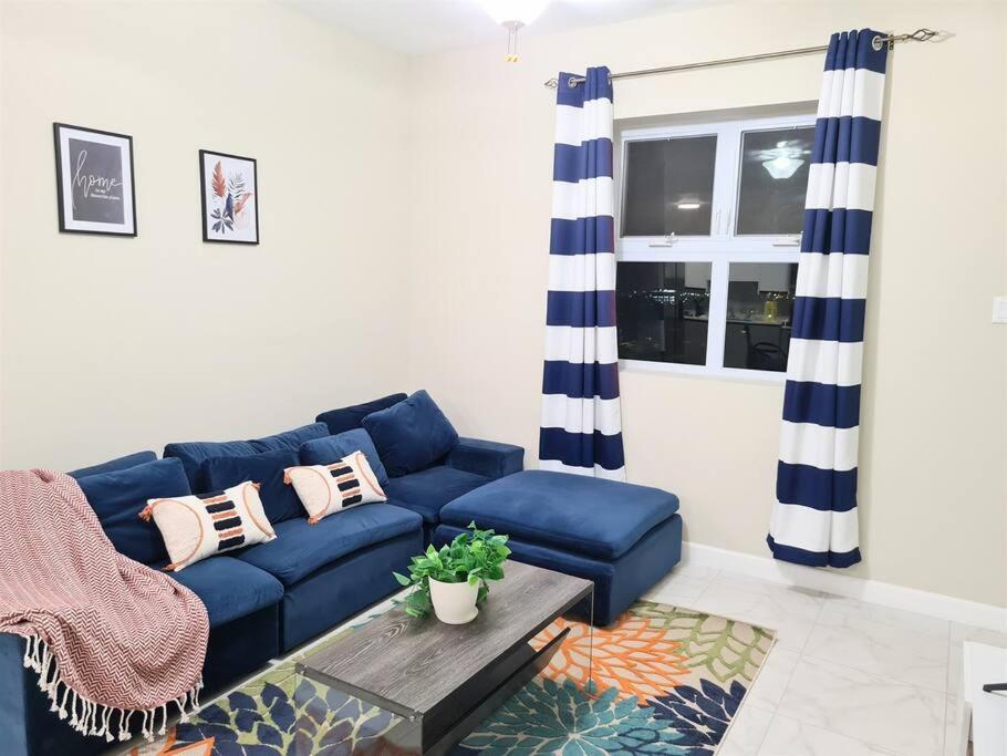 uma sala de estar com um sofá azul e uma mesa em Lofts 2B/R Lounge with City Views, Gym, Tennis Court em Kingston
