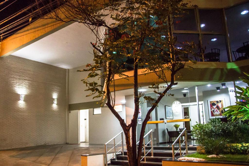 a tree in front of a building with stairs at Hotel Saint Martin in Bauru