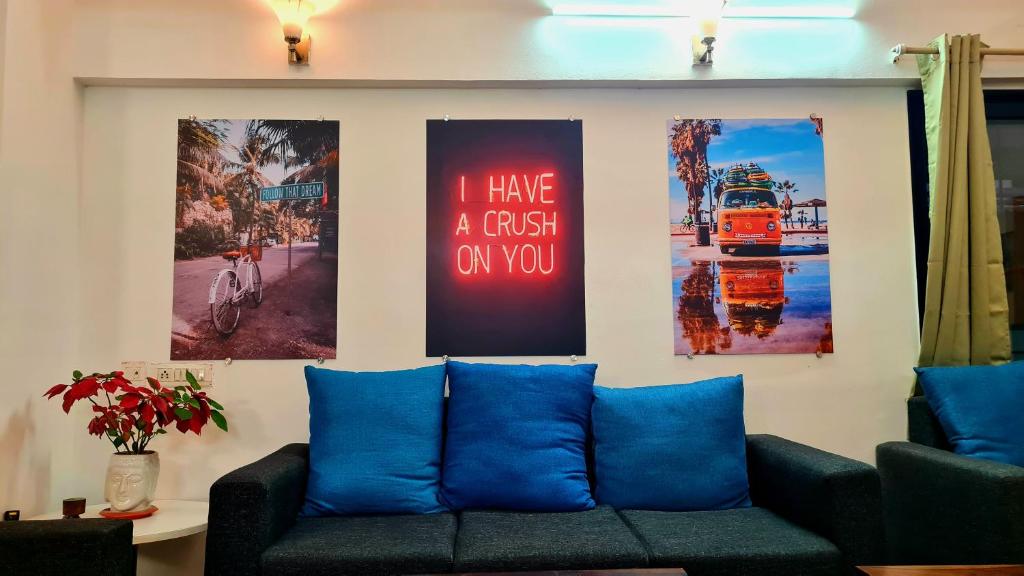 Lifespace- Spacious Hostel in a Luxurious Villa في بيون: غرفة معيشة مع أريكة وملصقات على الحائط