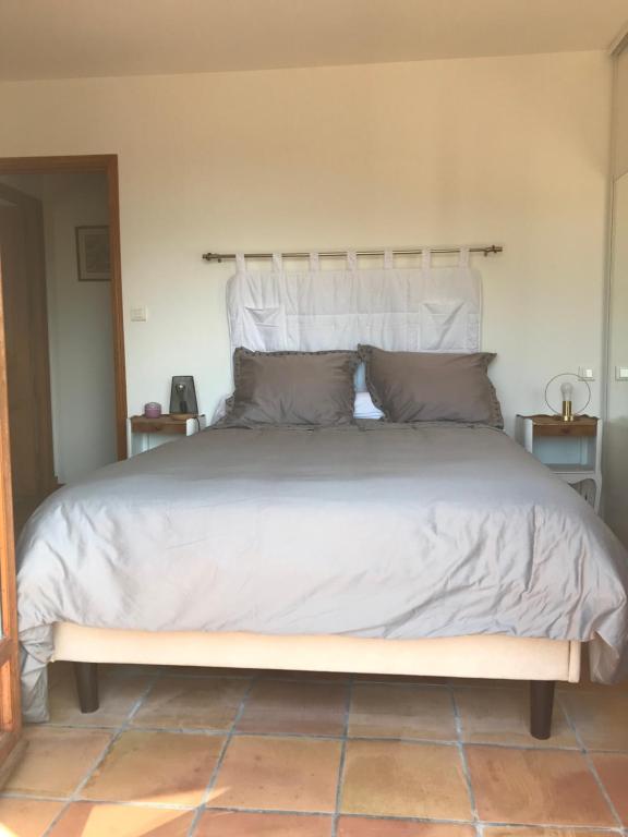 um quarto com uma cama grande com lençóis brancos e almofadas em Domaine Trevinella em Cauro