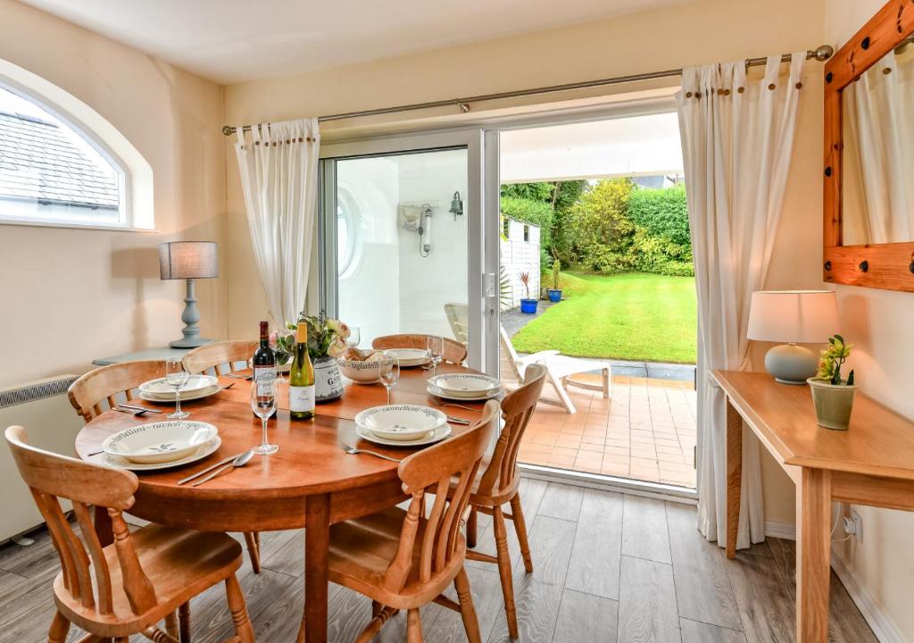 a dining room with a table and chairs and a patio at Summerdale in Abersoch