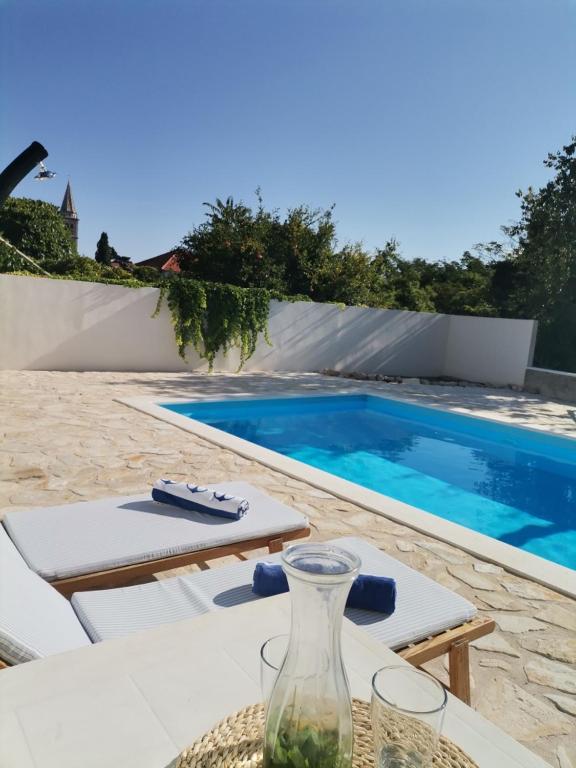 a glass vase sitting on a table next to a swimming pool at Holiday Home Hauser in Vrbanj