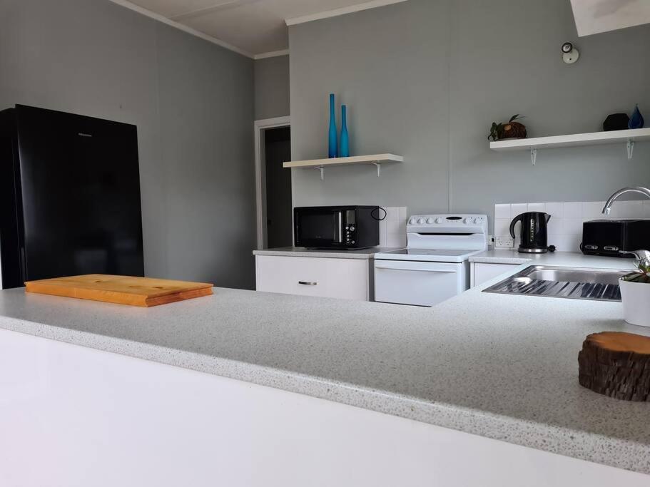 uma cozinha com electrodomésticos brancos e uma bancada em Holiday House On Sale em Tullah
