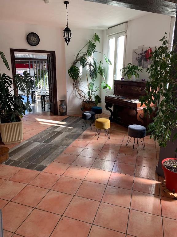 une chambre avec piano et plantes en pot dans l'établissement Hôtel Restaurant de l'Union, à Mirambeau