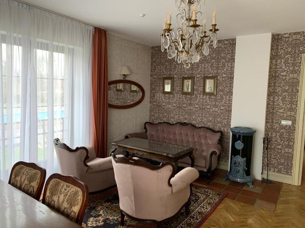 a living room with a couch and a table and chairs at Hotel Usadba in Kaliningrad