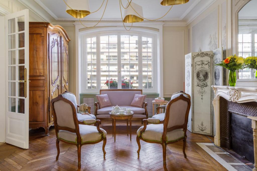 - un salon avec un canapé, des chaises et une cheminée dans l'établissement L'Hôtel Particulier - Paris Asnières, à Asnières-sur-Seine