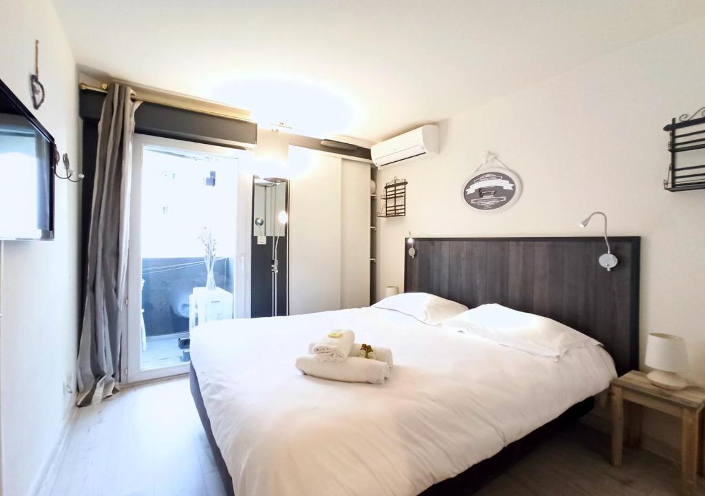 カンヌにあるViva Riviera Residence Palazzio Cannesのベッドルーム1室(白いベッド1台、テディベア付)