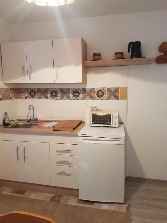a kitchen with white cabinets and a microwave on a counter at Ferienwohnung Wacker, Apartments und Zimmer in Züschen