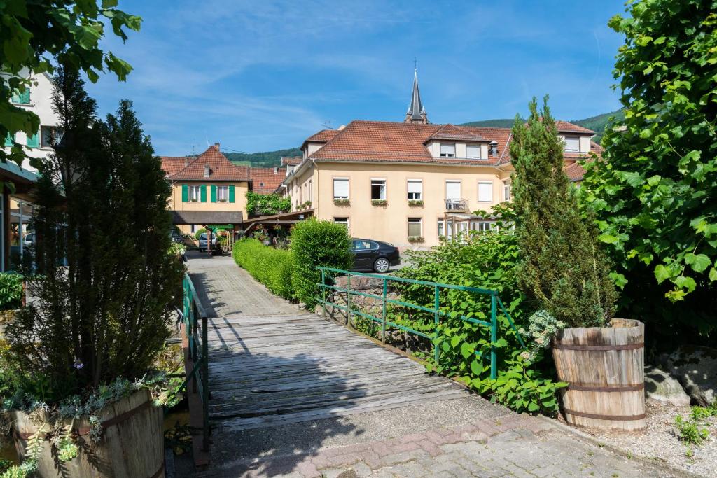 una calle en una ciudad con edificios y árboles en Hotel Restaurant Du Faudé, en Lapoutroie