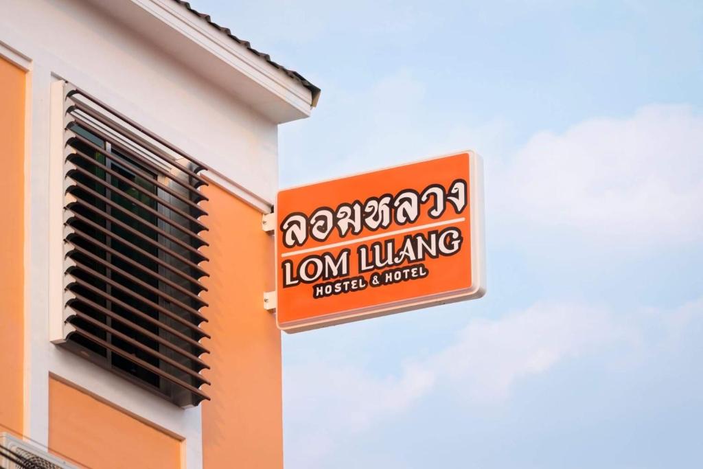 een teken voor een leeuw die aan de zijkant van een gebouw woont bij Lomluang hostel&hotel in Nan