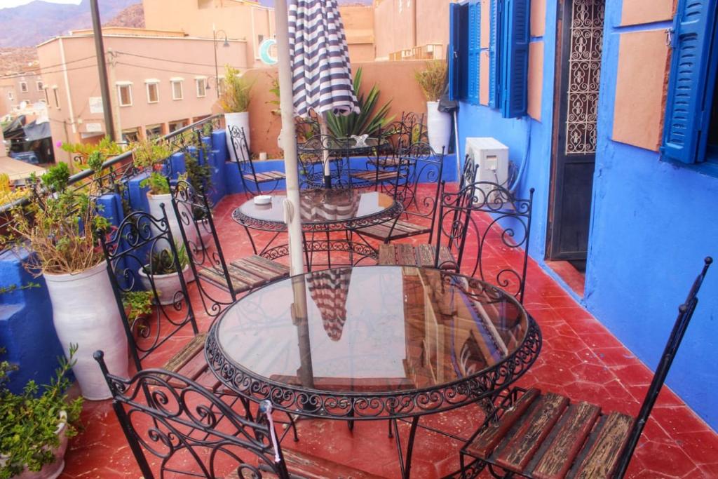 patio con mesa y sillas en el balcón en Auberge et hôtel les amis tafraout, en Tafraoute