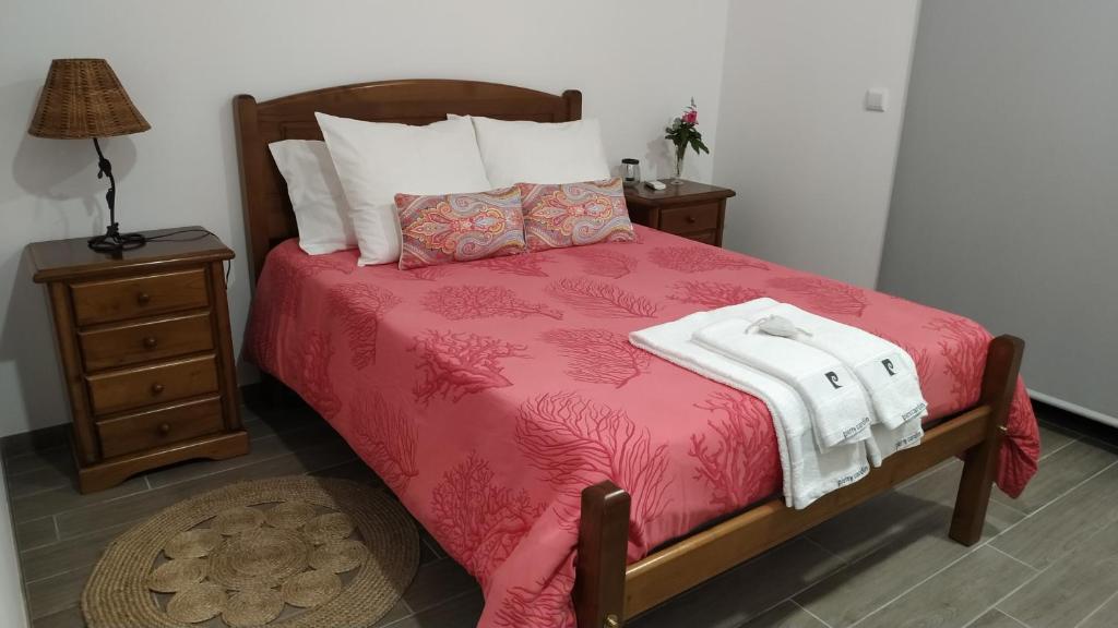 a bedroom with a bed with a red blanket and two night stands at QUINTA DO VALE in Valença