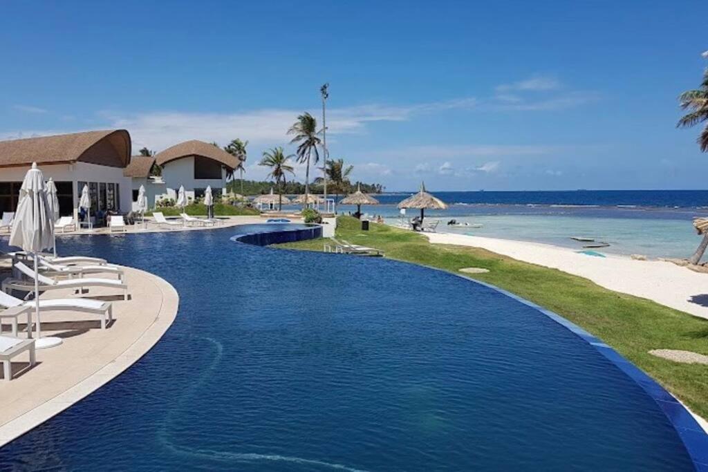 een zwembad met stoelen en het strand bij Apartamento en el mar Caribe, Playa Escondida Resort & Marina in María Chiquita