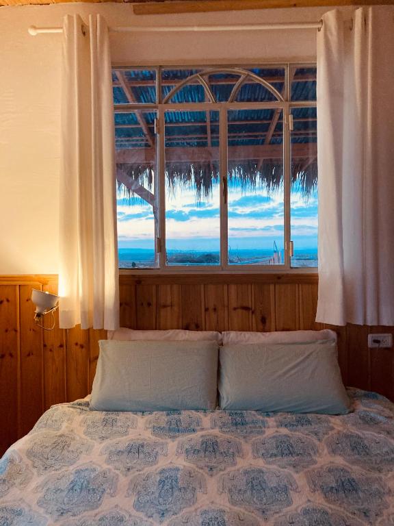 una camera da letto con un letto e una finestra di Tobiana Desert Lodging Negev a ‘Ezuz
