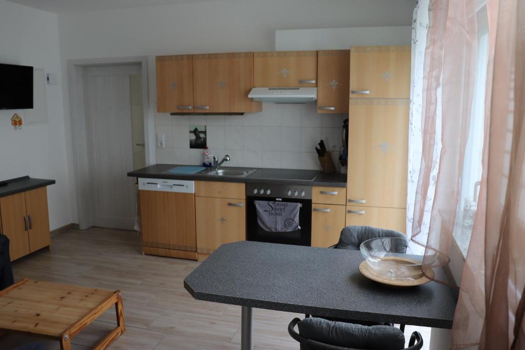 a kitchen with wooden cabinets and a table in a room at Mohnblume, die kleine Oase in Möhnesee