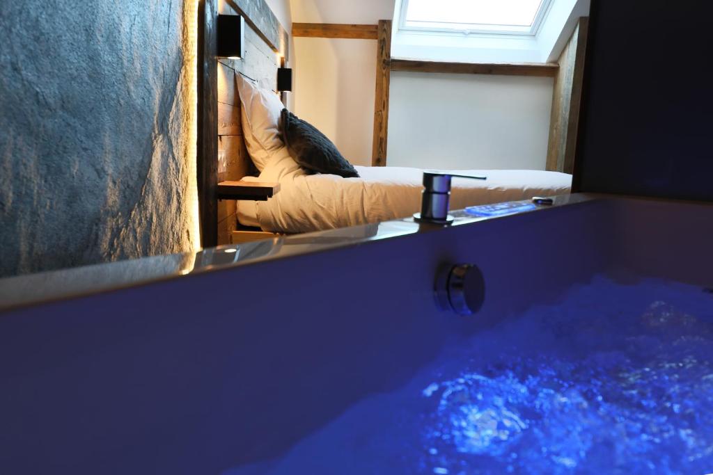 a room with a tub with a couch and a window at Superbe appartement, hypercentre au calme avec bain balnéo in Gérardmer