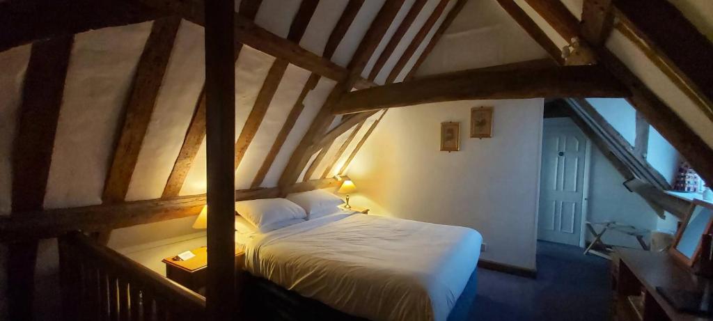 Un pat sau paturi într-o cameră la The Old Ram Coaching Inn