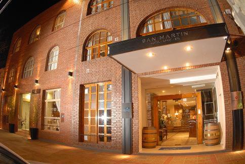 un gran edificio de ladrillo con una tienda con barriles en San Martin Hotel y Spa en San Rafael