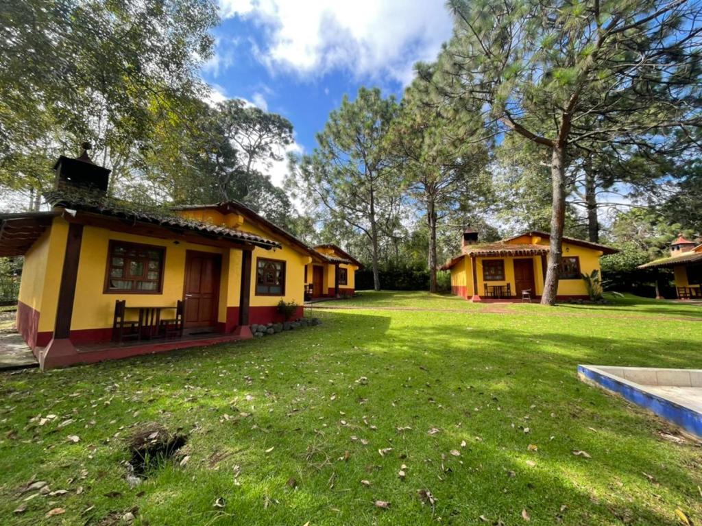 una pequeña casa amarilla con patio en Cabañas Rosy, en Mazamitla