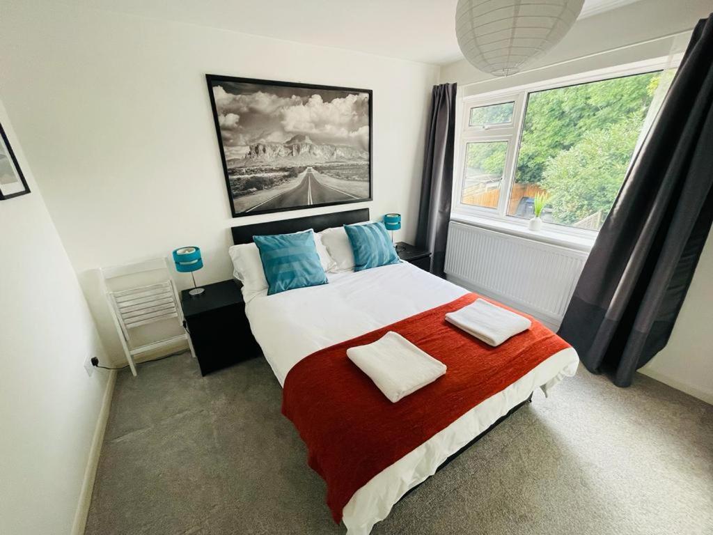 a bedroom with a large bed and a large window at Enfield Chase Apartment in Enfield