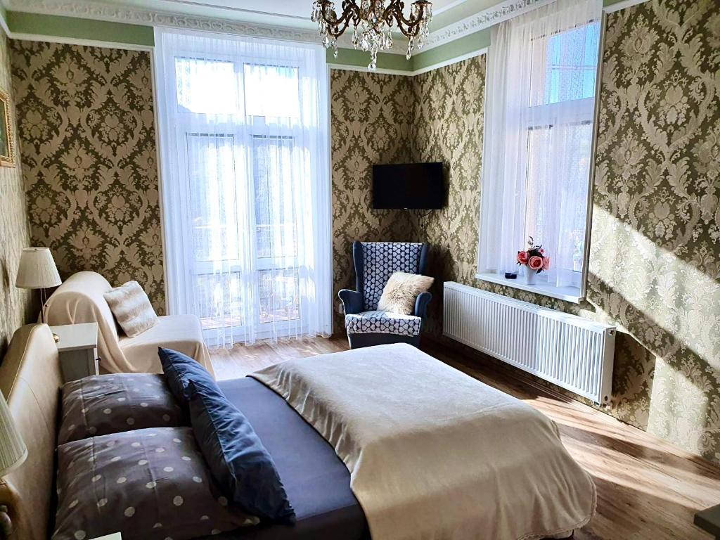 a bedroom with a bed and a couch and windows at Petřín No. 1 in Karlovy Vary