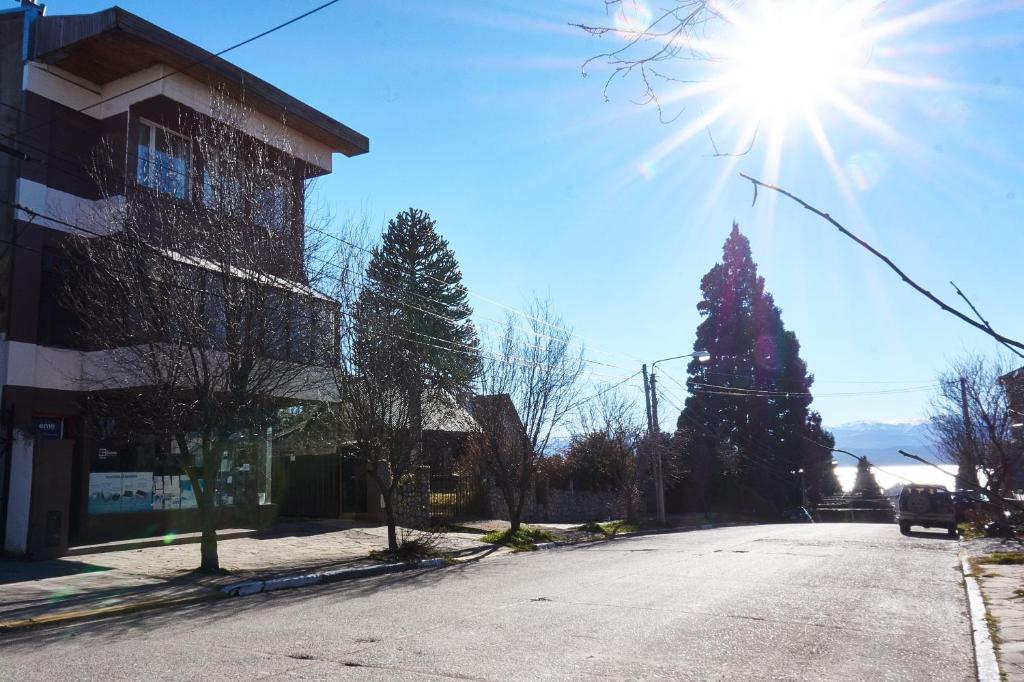 a street with a christmas tree and the sun at Apartamentos Rolando in San Carlos de Bariloche